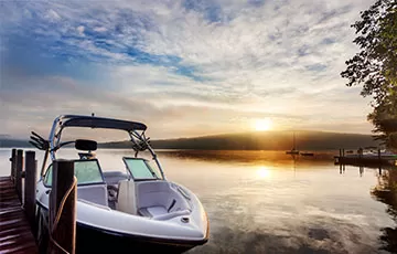 Boat docked in calm water with a scenic background.