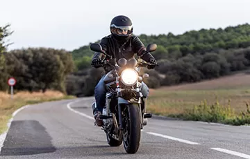 A man rides the motorcycle he financed through a credit union.