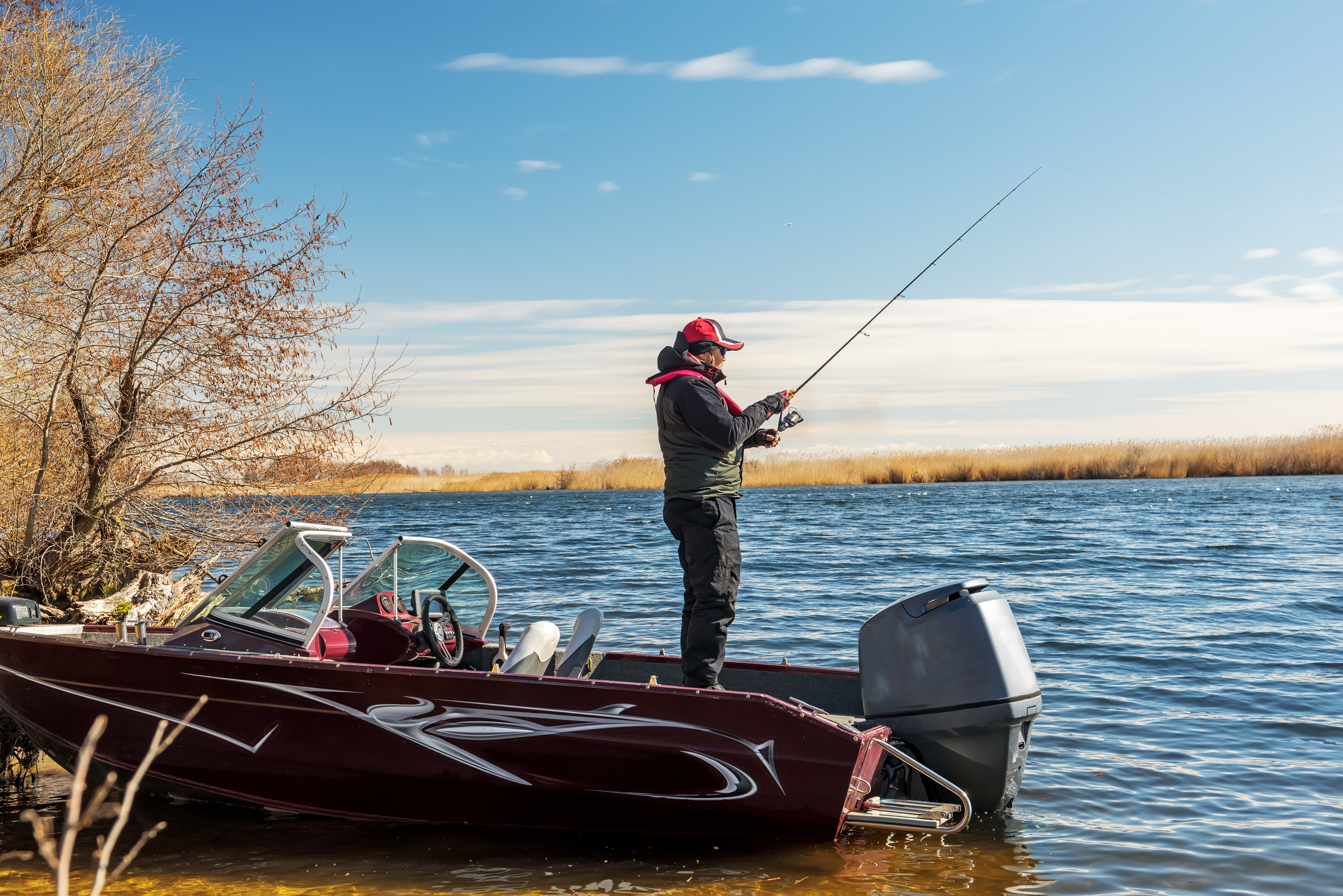 A man fishing off a new boat he financed with a recreational loan.